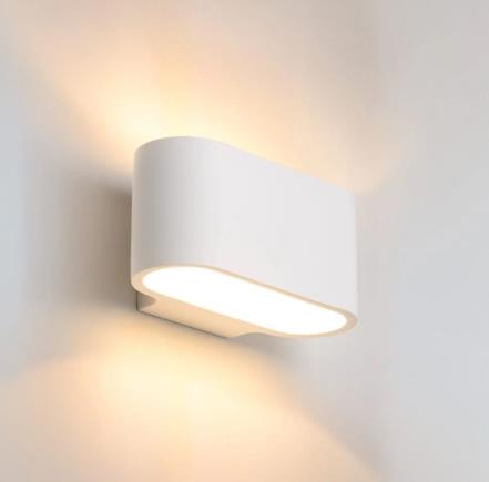 About Space Alta plaster wall light casting warm uplight on a pale wall