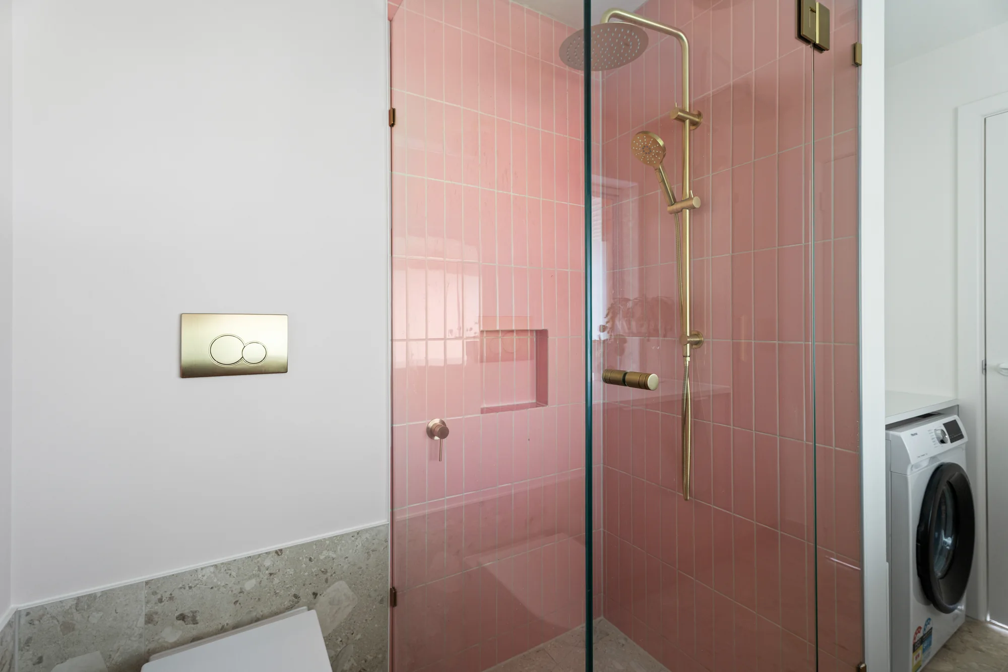Pink tiled shower with brass fittings at the completed Ivory Built Reservoir project