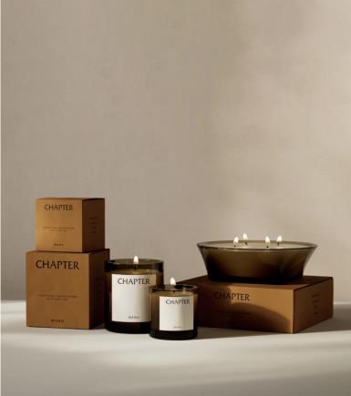 Candles and small ceramic accessories styled on a pale ledge in warm light